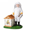 Cast resin figurine of a beekeeper using a smoker on a hive